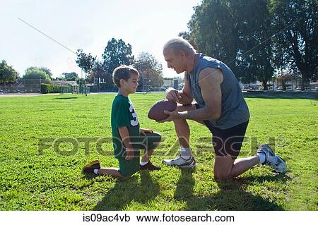 Stock Image - Boy and grandfather with american football. Fotosearch