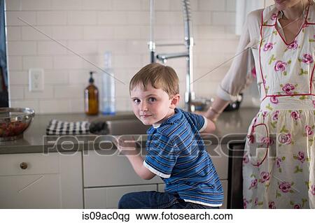 Boy at kitchen sink looking over shoulder View Large Photo Image Stock Image - Boy at kitchen sink looking over shoulder. Fotosearch