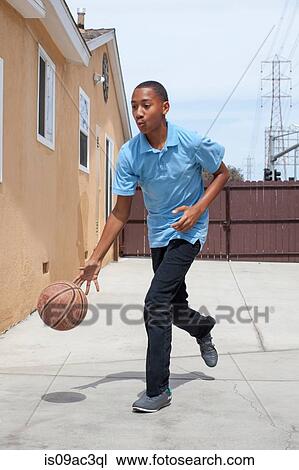 Boy bouncing basketball in yard View Large Photo Image Stock Image - Boy bouncing basketball in yard. Fotosearch