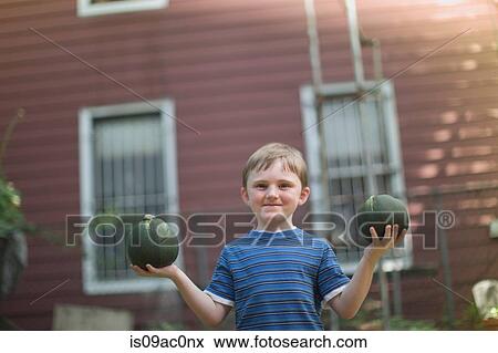Stock Photo - Boy holding two squashes. Fotosearch