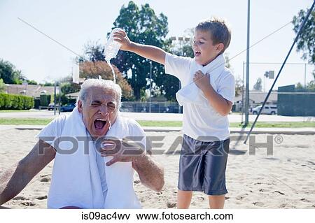 Stock Photo - Boy pouring water on grandfather. Fotosearch