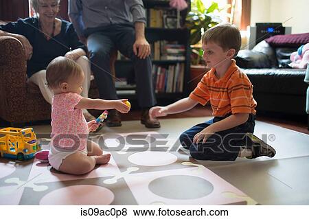 Brother playing with little sister on floor View Large Photo Image Stock Photo - Brother playing with little sister on floor. Fotosearch