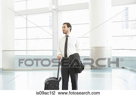 Businessman pulling wheeled suitcase View Large Photo Image Stock Image - Businessman pulling wheeled suitcase. Fotosearch