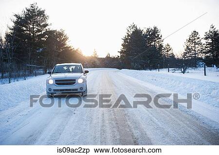 Stock Photography - Car driving along road in snow. Fotosearch