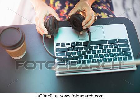 Stock Image - Close up of female hands holding headphones. Fotosearch