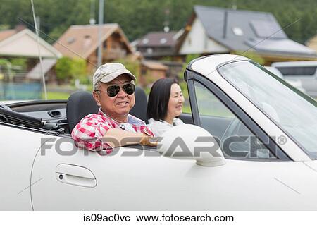 Couple enjoying leisurely drive in sports car View Large Photo Image Stock Image - Couple enjoying leisurely drive in sports car. Fotosearch