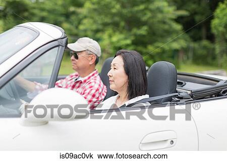 Couple enjoying leisurely drive in sports car View Large Photo Image Stock Image - Couple enjoying leisurely drive in sports car. Fotosearch