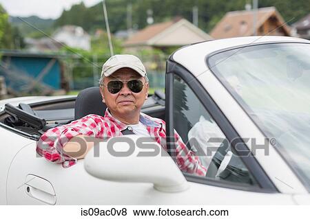 Stock Photo - Couple enjoying leisurely drive in sports car. Fotosearch
