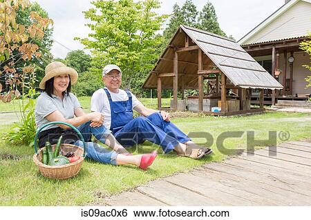 Couple relaxing on lawn View Large Photo Image Stock Photograph - Couple relaxing on lawn. Fotosearch