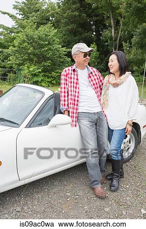 Couple standing beside car View Large Photo Image Stock Image - Couple standing beside car. Fotosearch