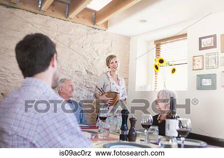 Stock Photo - Family in dining room at meal time. Fotosearch