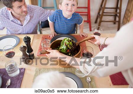 Stock Photography - Father and son looking up from dinner table. Fotosearch