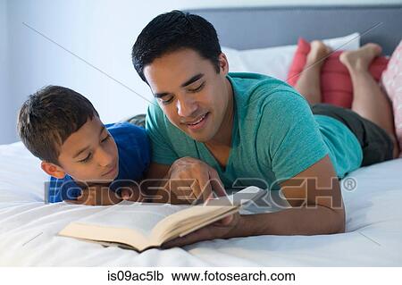 Father and son reading on bed View Large Photo Image Stock Image - Father and son reading on bed. Fotosearch