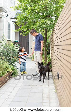 Stock Image - Father and young son on path with dog. Fotosearch