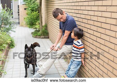 Stock Image - Father and young son with dog. Fotosearch