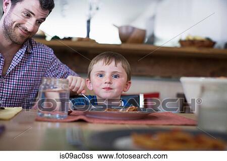 Stock Photograph - Father with son eating dinner. Fotosearch