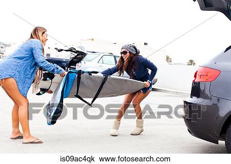 Female friends pulling cover from surfboard View Large Photo Image Stock Image - Female friends pulling cover from surfboard. Fotosearch