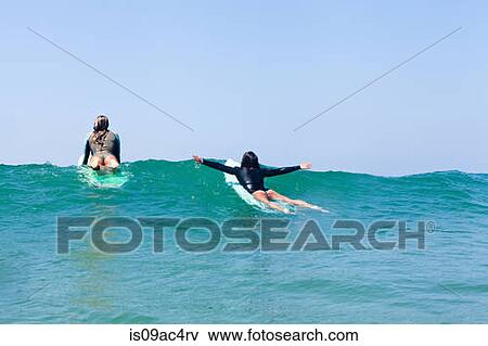 Stock Photo - Female friends surfing, Hermosa Beach, California, USA. Fotosearch