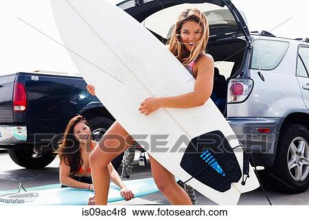 Stock Photo - Female friends with surf boards, Hermosa Beach, California, USA. Fotosearch