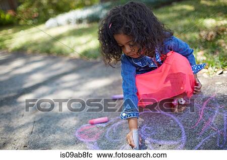 Stock Image - Girl drawing with chalk on the sidewalk. Fotosearch