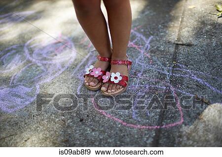 Stock Photo - Girl's legs standing on chalk drawing. Fotosearch