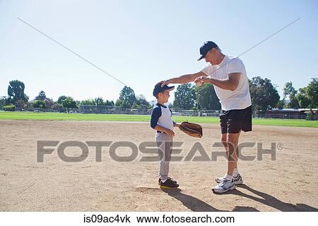 Stock Image - Grandfather and grandson on baseball field. Fotosearch