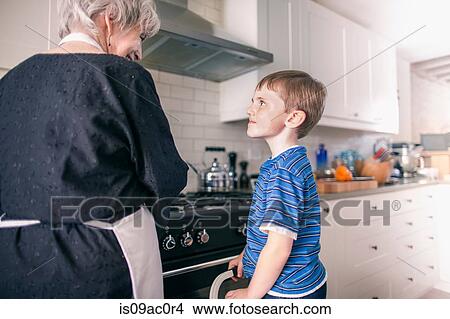 Picture - Grandmother and grandson preparing food at home. Fotosearch