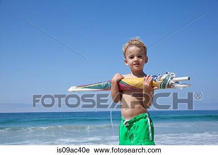 Male toddler holding sun umbrella View Large Photo Image Stock Image - Male toddler holding sun umbrella. Fotosearch