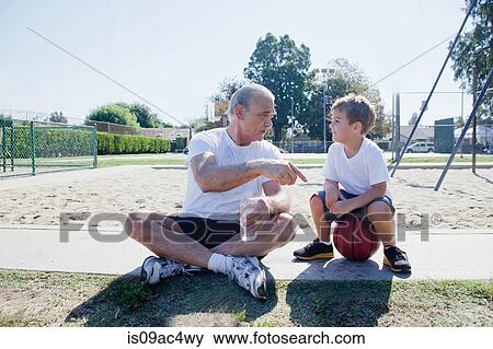 Stock Photo - Man giving grandson basketball pep talk. Fotosearch