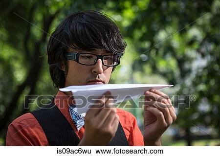 Stock Photograph - Man holding paper plane. Fotosearch