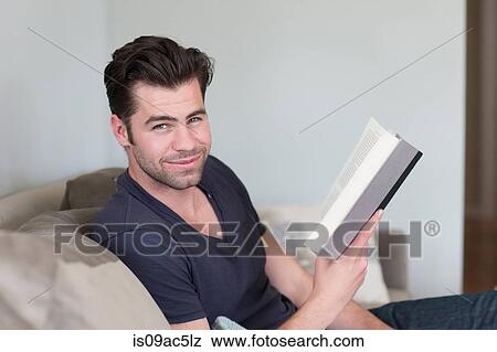 Stock Photo - Man looking up from book. Fotosearch