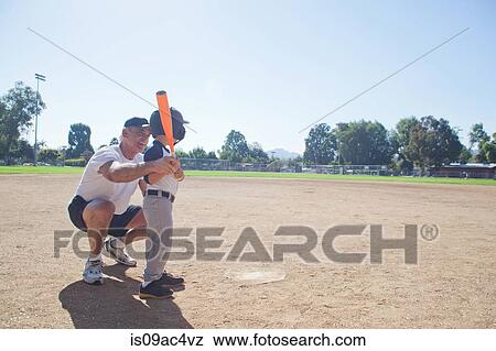 Stock Photo - Man teaching grandson to play baseball. Fotosearch
