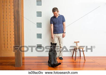 Stock Photo - Man training his pet dog. Fotosearch