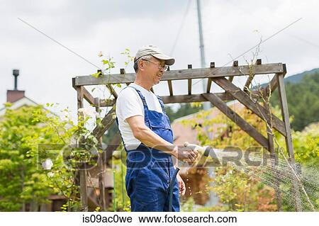 Stock Image - Man watering plants. Fotosearch