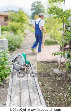 Stock Image - Man working in garden. Fotosearch