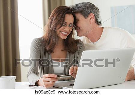 Stock Photo - Mature couple home shopping. Fotosearch