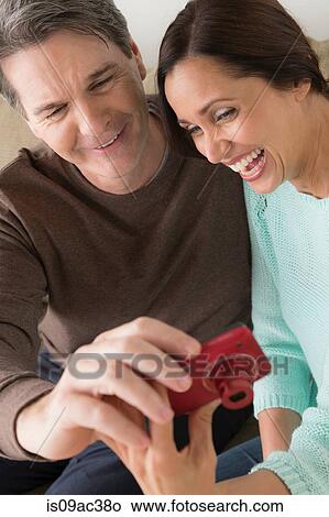 Mature couple looking at digital camera View Large Photo Image Picture - Mature couple looking at digital camera. Fotosearch
