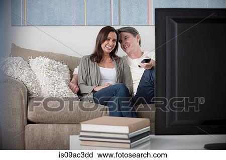Stock Image - Mature couple watching tv. Fotosearch