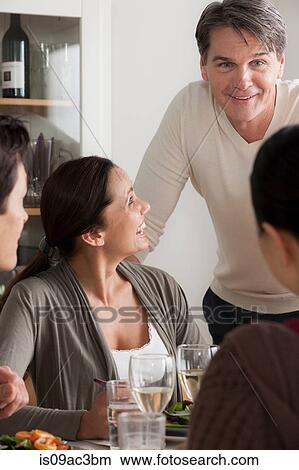 Picture - Mature friends enjoying meal together. Fotosearch