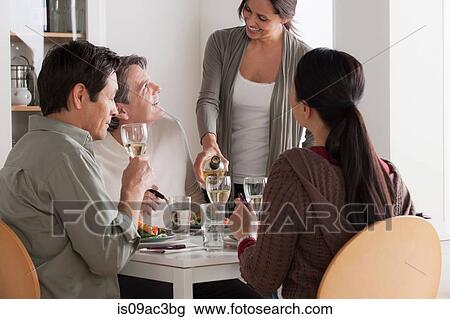 Mature friends enjoying meal together View Large Photo Image Stock Image - Mature friends enjoying meal together. Fotosearch