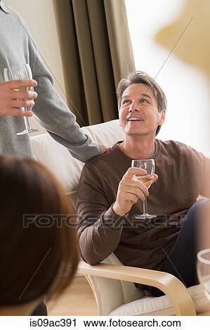 Mature friends socialising with white wine View Large Photo Image Stock Image - Mature friends socialising with white wine. Fotosearch