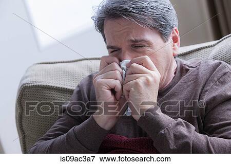 Stock Photo - Mature man blowing nose. Fotosearch