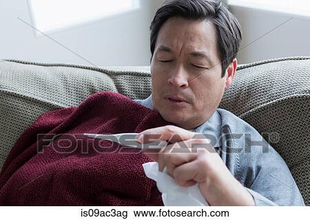Stock Image - Mature man taking temperature. Fotosearch