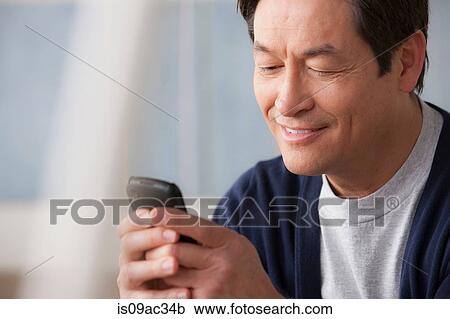 Stock Image - Mature man using cell phone. Fotosearch