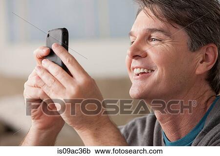 Stock Image - Mature man using cell phone. Fotosearch