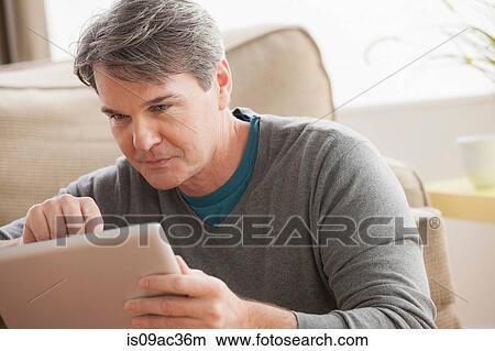 Mature man using digital tablet View Large Photo Image Picture - Mature man using digital tablet. Fotosearch