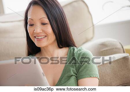 Stock Photography - Mature woman using digital tablet. Fotosearch
