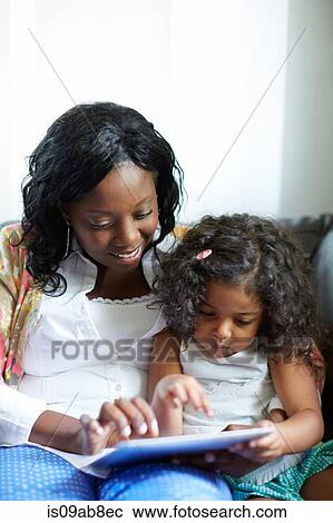 Mother and daughter using digital tablet View Large Photo Image Stock Image - Mother and daughter using digital tablet. Fotosearch