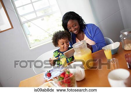 Stock Photo - Mother and son having breakfast. Fotosearch