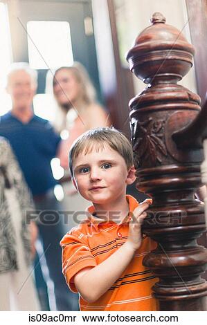 Stock Photography - Portrait of boy by wooden banister. Fotosearch